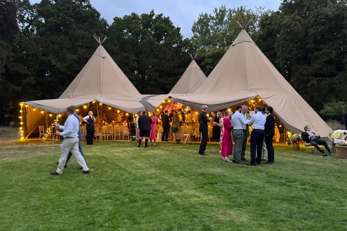 Guests at an outdoor tipi wedding supplied by MAV Hire